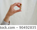 Psilocybin mushroom in woman's hand on grey background. Psychedelic magic mushrooms trip. Medical usage. Microdosing concept. Psilocybe cubensis 90492835