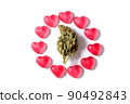Marijuana and valentines day concept. Cannabis bud with heart shaped candies on a white isolated background 90492843
