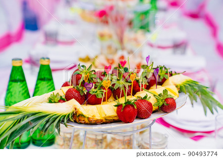 beautiful and original serving of strawberries in pineapple on the festive table beautiful and original serving of strawberries in pineapple on the festive table 90493774