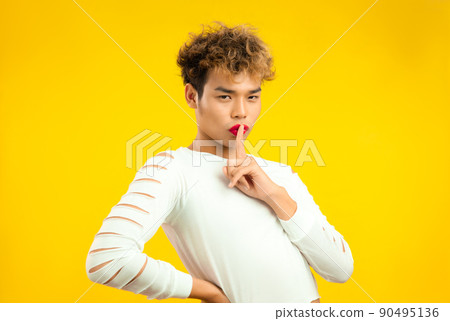 Portrait of a handsome gay man with red lip stick and white shirt. Transgender male LGBTQ+ concept 90495136