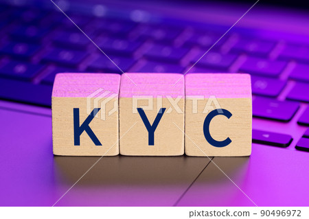KYC word on wooden blocks on laptop with colorful lights. Online Know Your Customer concept 90496972