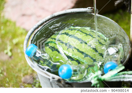 Cool the watermelon and ramune in a bucket 90498014