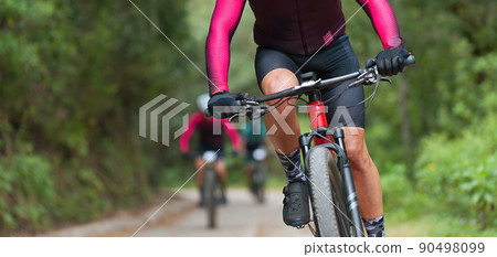 Mountain bikers riding on bike singletrack trail, mountain bike race Mountain bikers riding on bike singletrack trail, mountain bike race 90498099