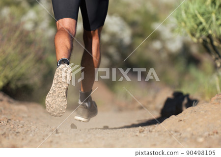 Athlete running sport feet on trail, selective focus on sole.Training workout on off road trail track design in advertising poster style Athlete running sport feet on trail, selective focus on sole.Training workout on off road trail track design in advertising poster style 90498105