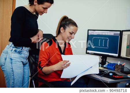 Within the heavy industry, a factory industrial engineer measures with a caliper and on a personal computer Designs a 3D model 90498718