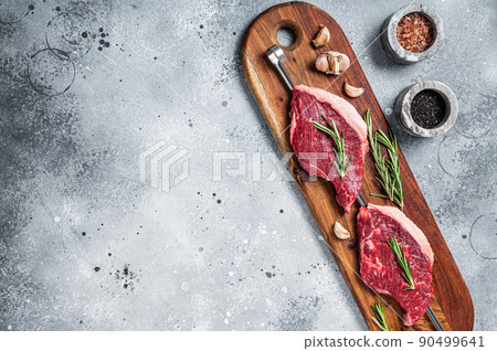 Raw Picanha Brazilian Grilling Steaks with herbs and spices. Gray background. Top view. Copy space Raw Picanha Brazilian Grilling Steaks with herbs and spices. Gray background. Top view. Copy space 90499641