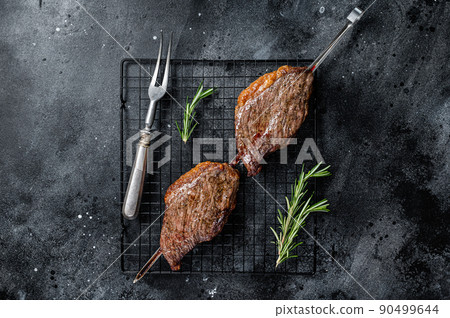 Picanha, traditional Brazilian barbecue, grilled beef meat steak. Black background. Top view 90499644