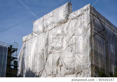 Reconstruction of an old brick house. Scaffolding for construction, construction site. Selective focus 90500147