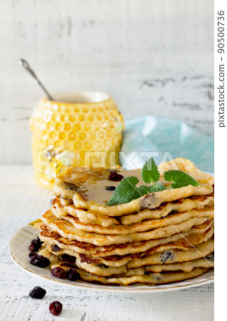 Oatmeal Pancakes with honey and raisins on a wooden table Oatmeal Pancakes with honey and raisins on a wooden table 90500736