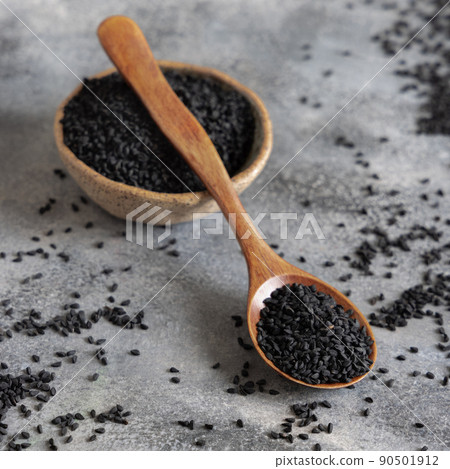 Bowl of Indian spice Black cumin (nigella sativa or kalonji) seeds close up with a wooden spoon Bowl of Indian spice Black cumin (nigella sativa or kalonji) seeds close up with a wooden spoon 90501912