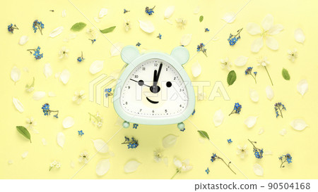 Summer composition with from flowers and clock, alarm on yellow background. Flat lay, top view 90504168
