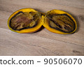 Close-up of a completely rotten cut mango on a wooden background 90506070