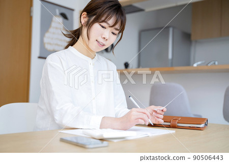 A woman holding a household account book 90506443