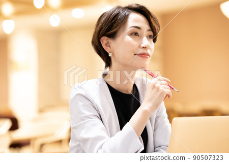 使用筆記本電腦的辦公室休閒中年婦女 使用筆記本電腦的辦公室休閒中年婦女 90507323
