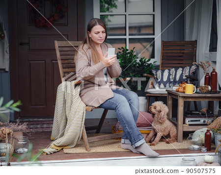 smiling woman with dog outdoors making selfie 90507575
