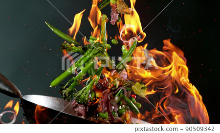 Closeup of chef throwing beef pieces with vegetable. 90509342
