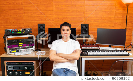 portrait of young asian professional music producer smiling with friendly eyes in recording studio 90509362