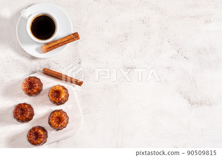 A cup of coffee and French dessert canele on grey background A cup of coffee and French dessert canele on grey background 90509815