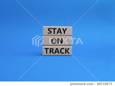 Stay on track symbol. Wooden blocks with words 'Stay on track'. Beautiful blue background. Business and 'Stay on track' concept. Copy space. 90510675