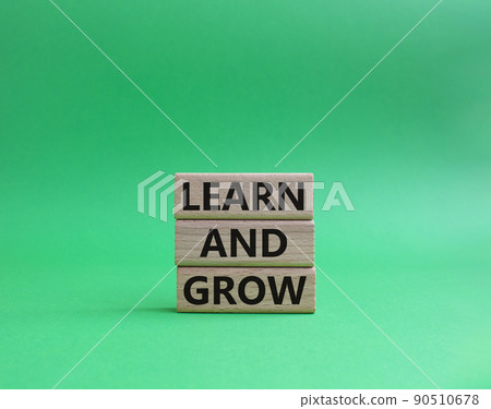 Learn and grow symbol. Concept words 'Learn and grow' on wooden blocks. Beautiful green background. Business and Learn and grow concept. Copy space. 90510678
