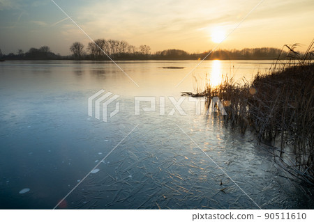 View on a frozen lake during sunset View on a frozen lake during sunset 90511610