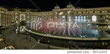 Place Vendome Mall  in Lusail city, Qatar interior view at night showing the architecture of the mall with big fountain in foreground 90512035