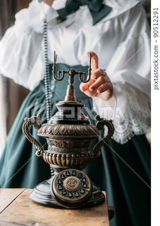 Beautiful woman in vintage blouse costume with retro phone. Historical dresses, vintage outfits, reconstruction. 90512291