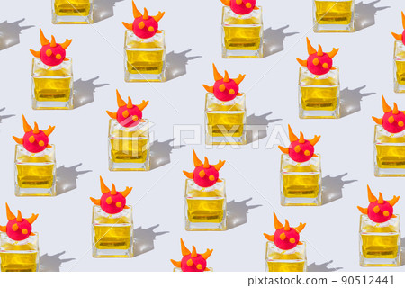 Pattern made of a bottle of yellow perfume decorated with a cap of shaped multicolored plasticine on white background 90512441