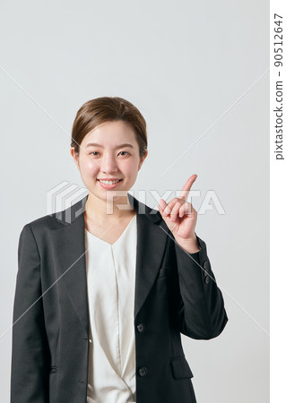 一個穿著夾克的女商人用食指 一個穿著夾克的女商人用食指 90512647