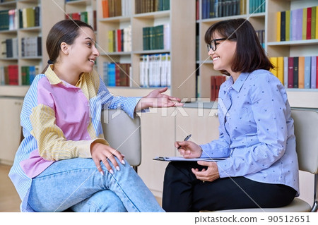 Psychologist, high school behavior counseling teenage student in library Psychologist, high school behavior counseling teenage student in library 90512651