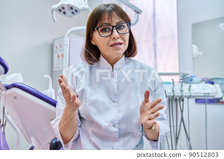 Talking doctor dentist looking at webcam, making video call conference, in dental office 90512803