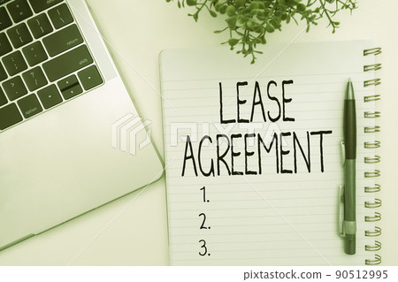 Conceptual caption Lease Agreement. Business concept Contract on the terms to one party agrees rent property Office Supplies Over Desk With Keyboard And Glasses And Coffee Cup For Working 90512995