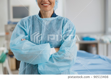 Close up of female surgeon standing in operating room with crossing hands Close up of female surgeon standing in operating room with crossing hands 90513408