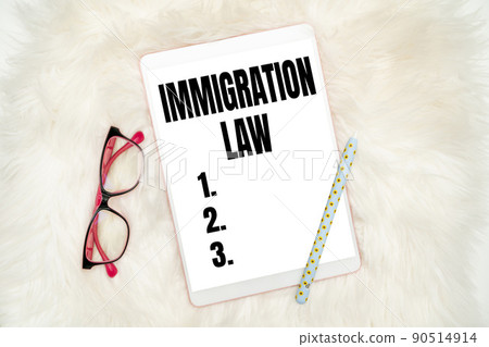 Sign displaying Immigration Law. Word for Emigration of a citizen shall be lawful in making of travel Office Supplies Over Desk With Keyboard And Glasses And Coffee Cup For Working 90514914