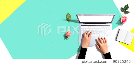 Woman using her laptop with pink roses 90515243