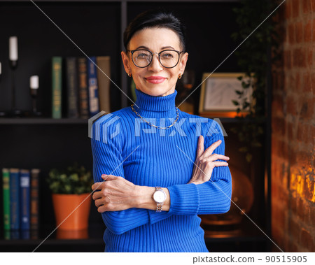 Confident mature businesswoman with crossed arms in home office Confident mature businesswoman with crossed arms in home office 90515905