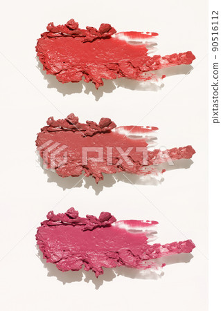 Cosmetics lipstick swatches. Peach, pink, red and coral toned styled cosmetics flat lay. Closeup colour palette. Creative concept photo of cosmetics samples isolated on white background Cosmetics lipstick swatches. Peach, pink, red and coral toned styled cosmetics flat lay. Closeup colour palette. Creative concept photo of cosmetics samples isolated on white background 90516112