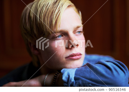 Wondering what the future holds. Thoughtful and handsome young blonde guy with very blue eyes. 90516346