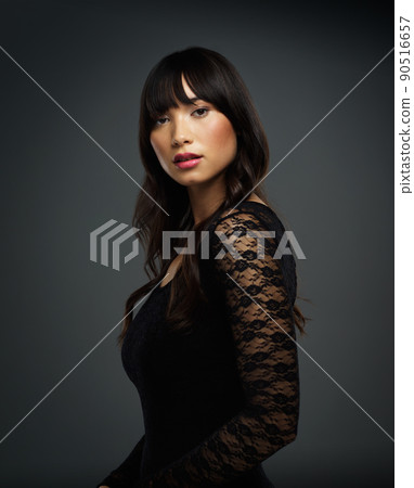 Confidence makes all the difference. Studio shot of a beautiful young woman posing against a dark background. 90516657