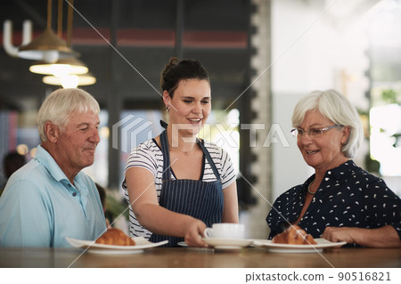 Everything is delicious at this cafe. Cropped shot of a senior couple being served by a waitress. 90516821