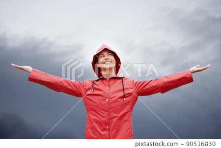 Im ready for anything. Cropped shot of an attractive young woman standing in the rain. 90516830
