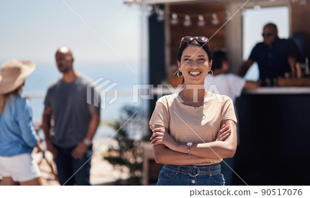 I finally made it. Portrait of a cheerful young woman smiling brightly while standing outside on a beach promenade during the day. 90517076