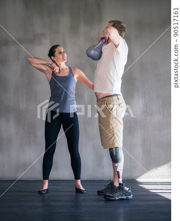 Devoted to my patients health. Shot of a female physiotherapist having a session with a young male amputee. 90517161