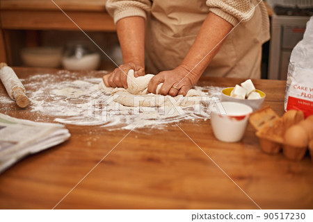 Made with love.... A cropped view of hands working the dough while baking in a kitchen. Made with love.... A cropped view of hands working the dough while baking in a kitchen. 90517230