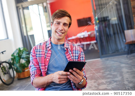 This tablet had made business so simple. Cropped shot of a handsome young businessman working in the office. This tablet had made business so simple. Cropped shot of a handsome young businessman working in the office. 90517350