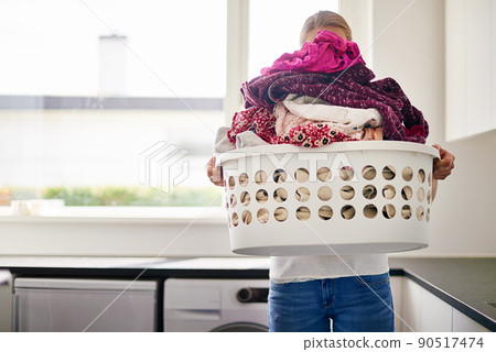 Its laundry day. Cropped shot of young woman doing laundry at home. 90517474