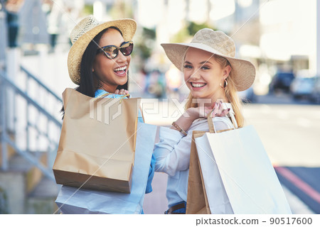 This is our little way of spoiling ourselves. Cropped portrait of two attractive young girlfriends smiling while walking with shopping bags in the city during the day. This is our little way of spoiling ourselves. Cropped portrait of two attractive young girlfriends smiling while walking with shopping bags in the city during the day. 90517600