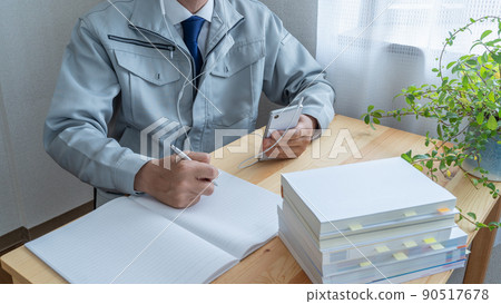 Watching smartphones | Image of a construction businessman aiming to acquire qualifications while working Watching smartphones | Image of a construction businessman aiming to acquire qualifications while working 90517678