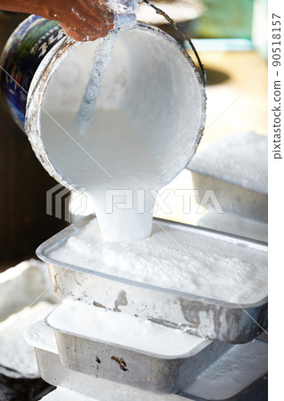 A delicate process. A Thai man pouring liquid rubber into moulds to set. 90518157