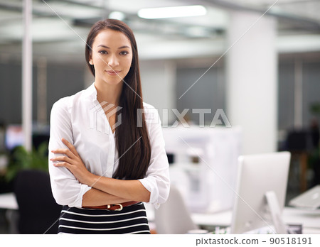 Business confidence. Portrait of an attractive young businesswoman standing with her arms folded in the office. 90518191